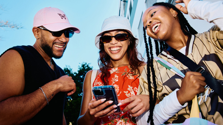 Three young people looking at a smartphone
