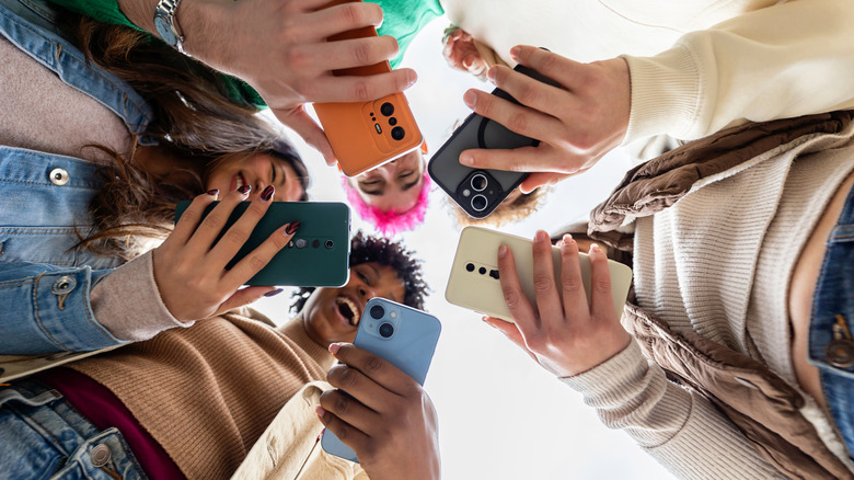 A group of yougn people all looking at their smartphones
