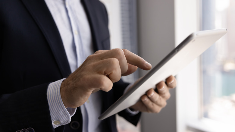 a man in a suit using a tablet