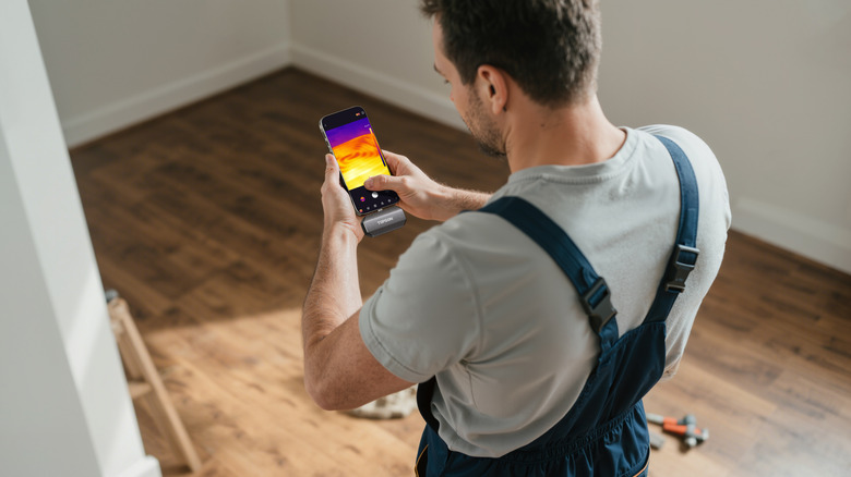 A man using the TOPDON TC002C Duo to measure heat