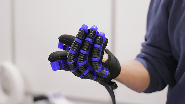 A flexible robotic hand gauntlet being used for rehabilitation.