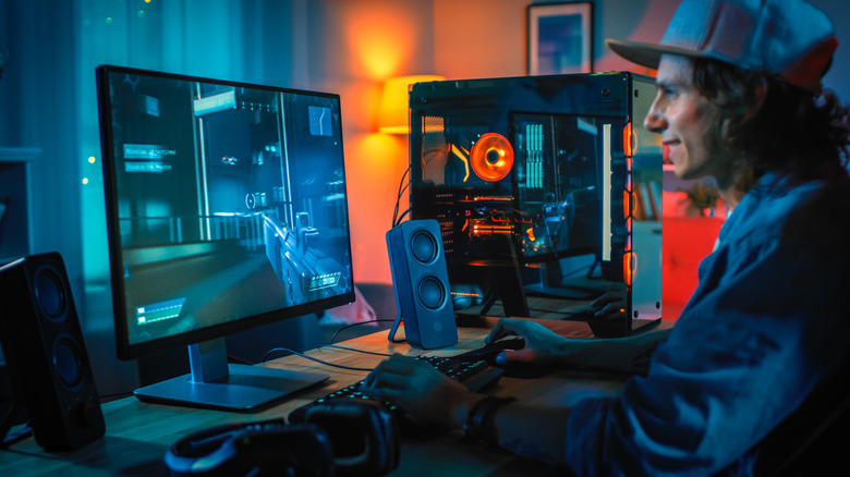 A guy in a hat gaming on his PC.