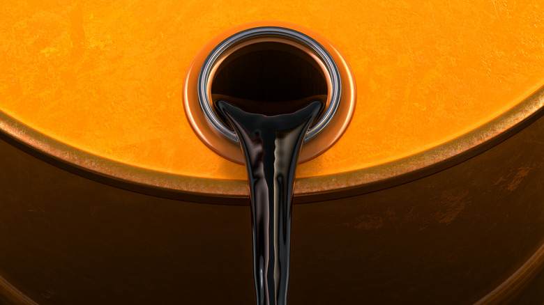 Close up of crude oil pouring out of a barrel.