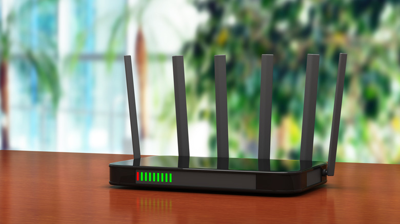 wireless router on a table, blurred background with plants visible