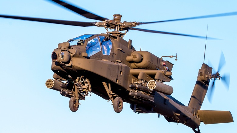 A Apache Attack Helicopter AH-64 flying  with the blue sky in the background
