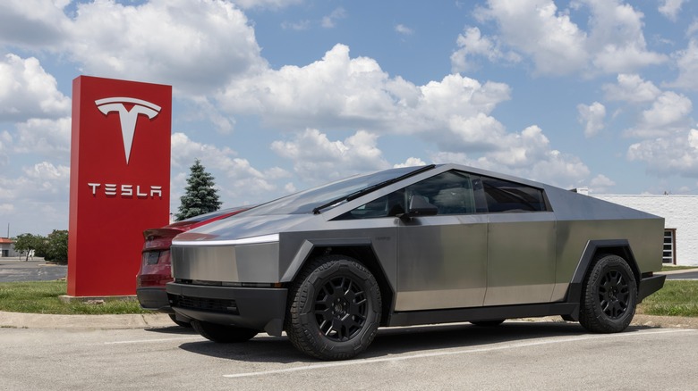 Tesla Cybertruck parked near Tesla sign