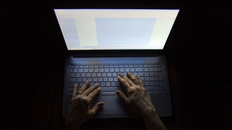 A person using a computer in the dark
