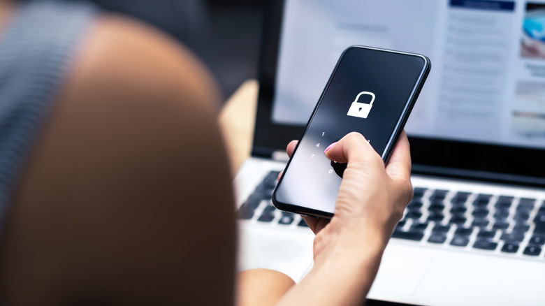Smartphone in someone's hand as they enter a security code to unlock