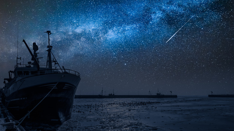 ship in frozen harbor, starry sky in the background, shooting star in the distance