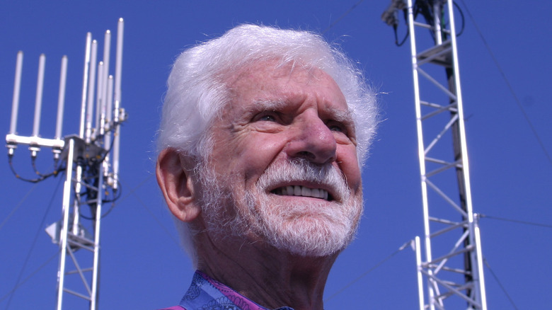 Dr. Martin Cooper standing outside with two cellular towers behind him.
