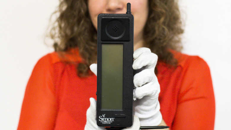 A woman holding an IBM Simon