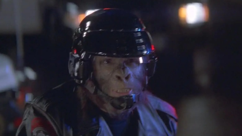 An actor dressed as an ape from the 2001 film "Planet of the Apes," the ape/human-hybrid is wearing a black helmet and what appears to be a uniform