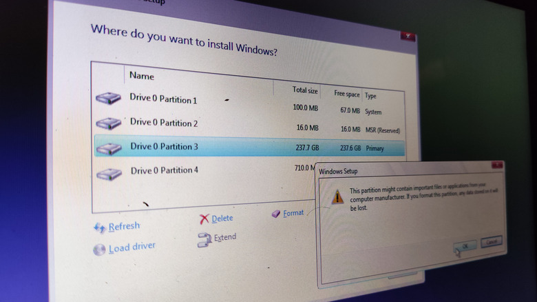 Screenshot of Windows install with disc partition menu visible.