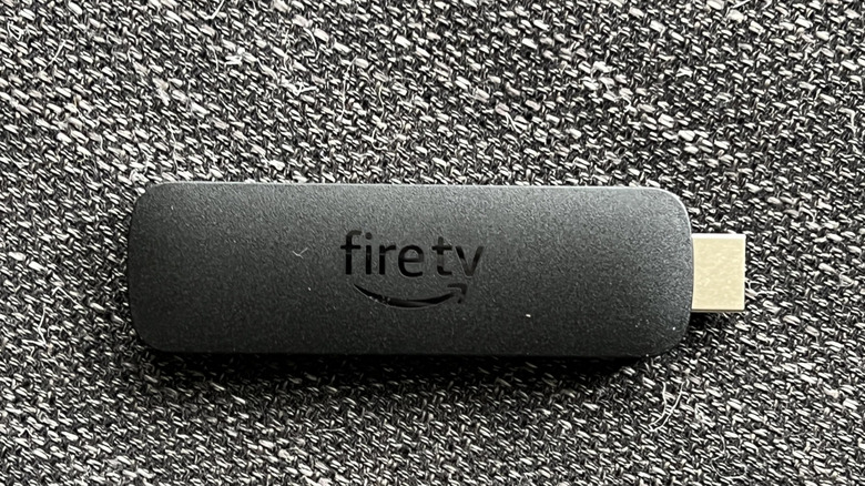 An Amazon Fire TV Streaming Stick on a carpet.