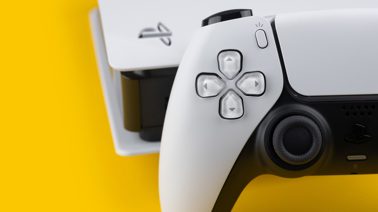 PlayStation 5 controller and console on a yellow background