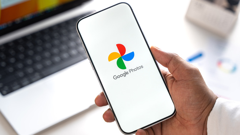 Google Photos logo shown on a smartphone display in someone's hands