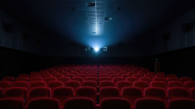 Empty theater, showing seats and the projector at the back of the room
