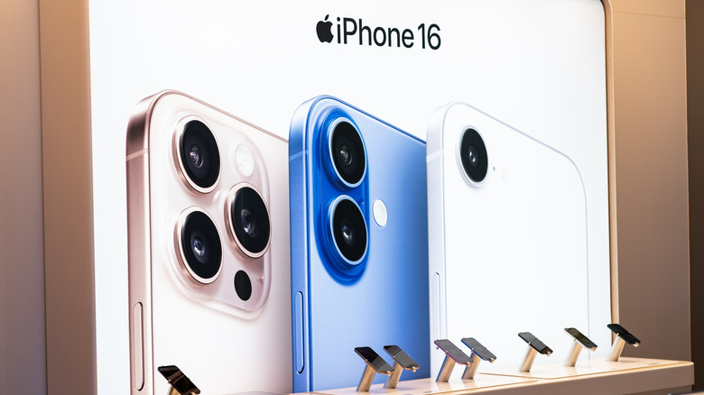 An iPhone 16 section in a store featuring a poster of the iPhone 16 Pro, iPhone 16, and iPhone 16e.