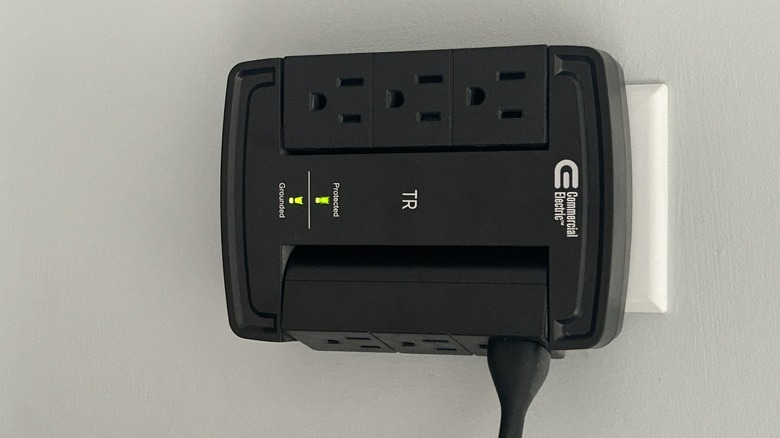 A black surge protector connected to socket