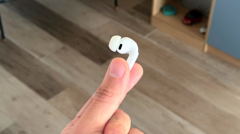 A hand holding one of the AirPods Pro 3 earbuds