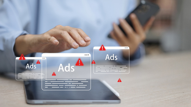 a person hovering over ads on a window with a warning sign next to them