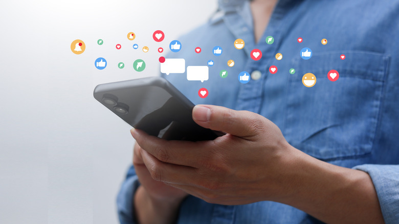 Person holding phone with icons indicating messaging activity