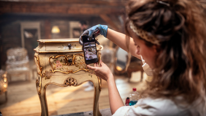 a person taking the photo of an antique item from their smartphone