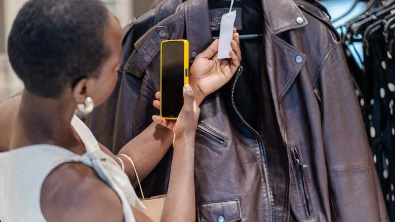 person looking for the price of a jacket using their phone