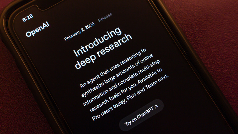 A photograph of an iPhone with ChatGPT open on the screen. The introducing deep research press release is shown on-screen.