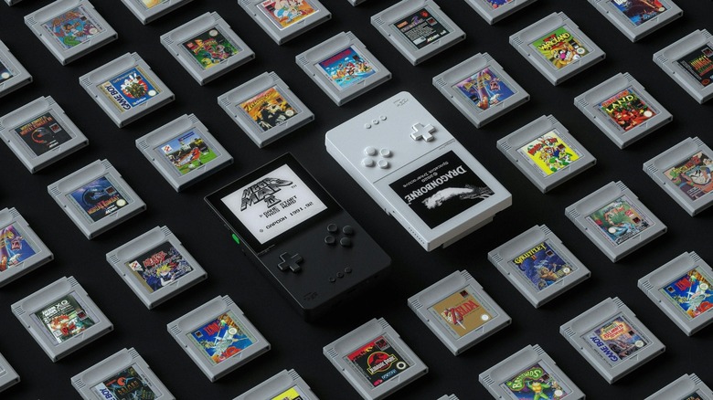 Two Analogue Pockets surrounded by Game Boy cartridges.