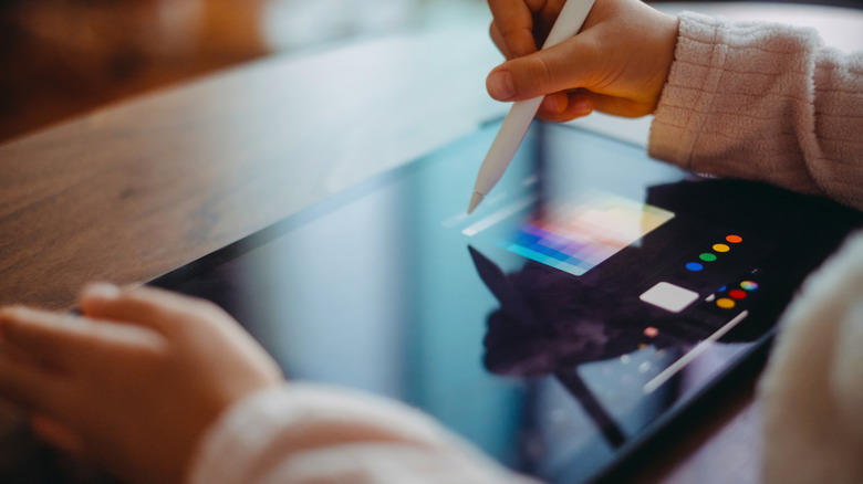 Close up of a person drawing on a digital tablet