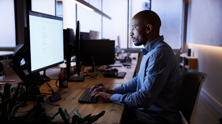 A man works at a desktop PC