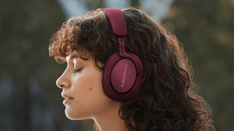 A female model wearing a pair of Bowers & Wilkins Px7 S2e headphones