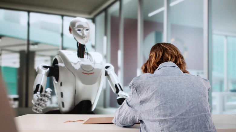 woman interacting with humanoid robot in office environment