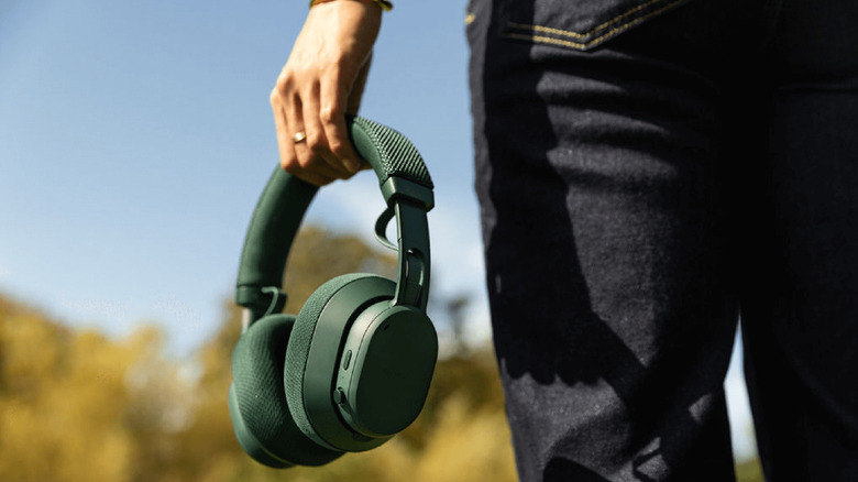 A person holding the Fairphone Fairbuds XL wireless headphones