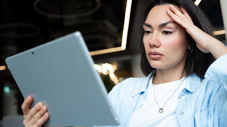 A woman who is frustrated with her tablet