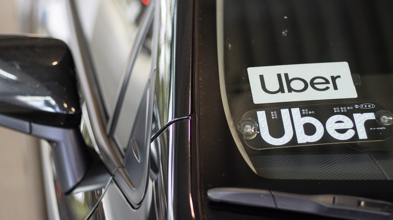 Uber sticker on a car windshield.