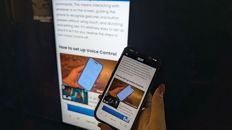 A hand holding an iPhone up to a TV with the same BGR article showing on both