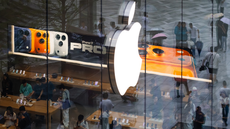 iPhone 17 Pro signage seen through the glass window of an Apple store.