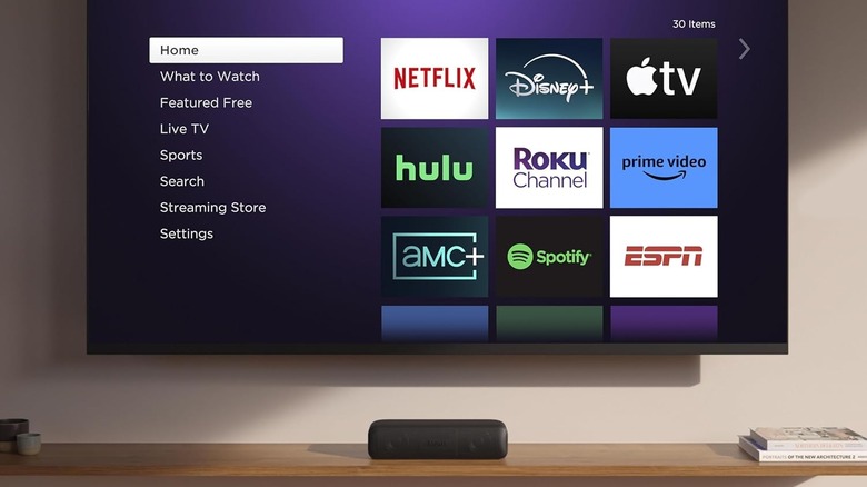 The Roku Streambar SE set up under TV with Roku TV OS on display.
