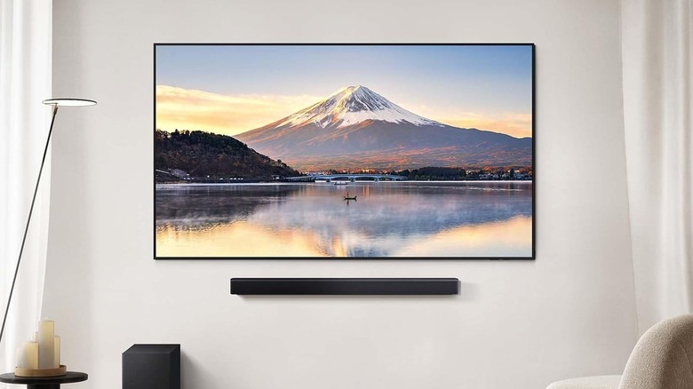The Samsung HW-B550F Soundbar mounted below a wall-mounted TV.
