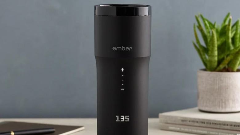 Th Ember Travel Mug 2+ powered on and placed on a desk.