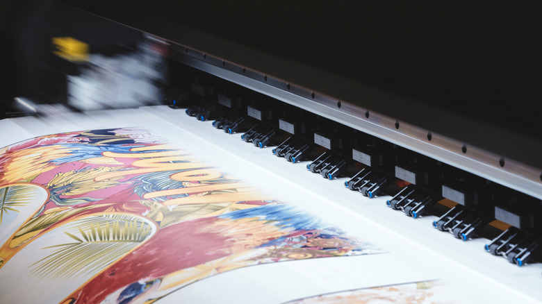 A close-up of an inkjet printer as it prints a colorful sheet