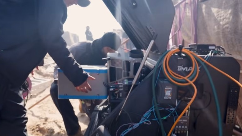 Film crew loading film box into an IMAX camera, which is inside the Blimp casing.