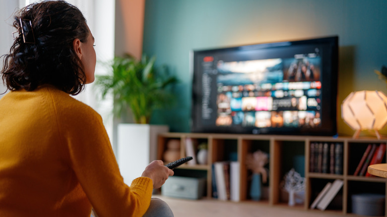 woman using a remote with her TV and entertainment system