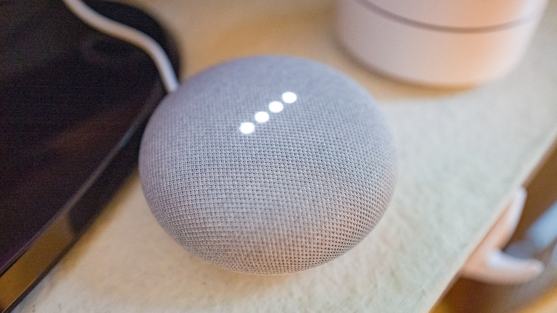 A close up of a Google Home speaker sitting on a desk.