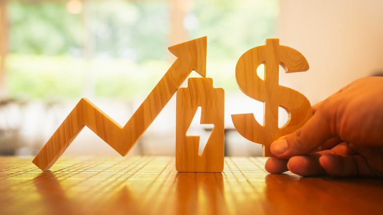 a dollar sign and an energy sign with an upwards arrow