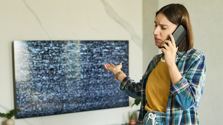 A woman on the phone with customer service to discuss her broken TV