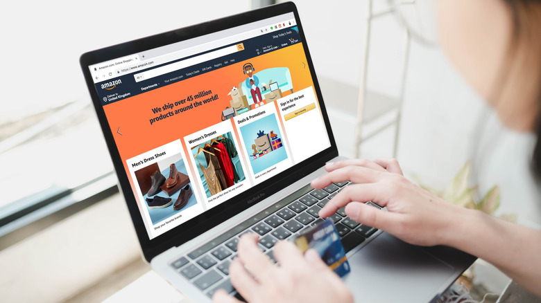 A person browsing Amazon with a credit card in their hand