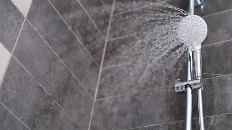 a silver shower faucet sprays water